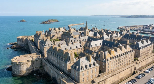 Vue aérienne ou photographie de la côte et de la ville historique de Saint-Malo, montrant les remparts médiévaux, les toits de pierre et la mer en arrière-plan, illustrant l'une des zones d'intervention principales de l'entreprise dans un rayon de 100 km.